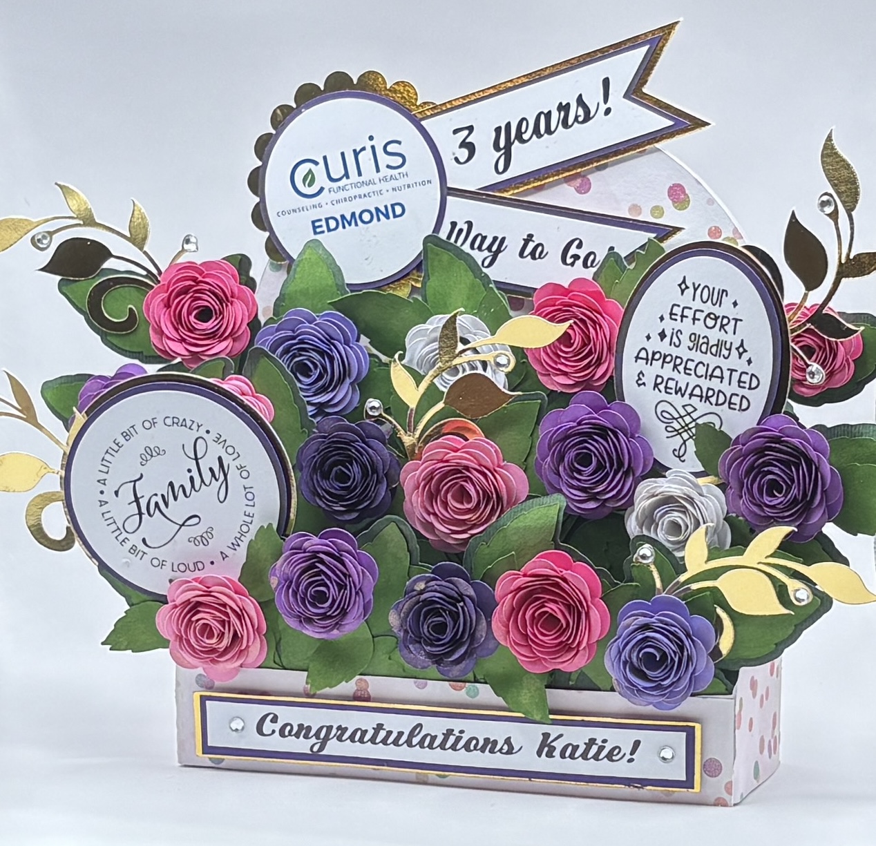 Corporate work anniversary keepsake with hand-rolled paper roses and a printed company logo medallion
