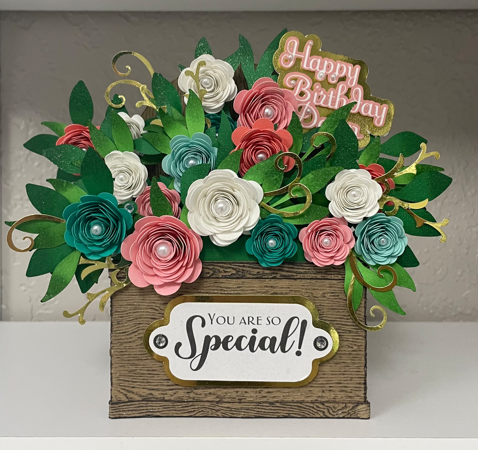 Classic keepsake: a rustic wood box overflowing with handrolled pink, teal and ivory paper roses with a gold-framed 'You Are So Special' plaque